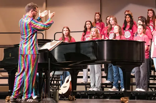 Spring pop show director conducting from the piano