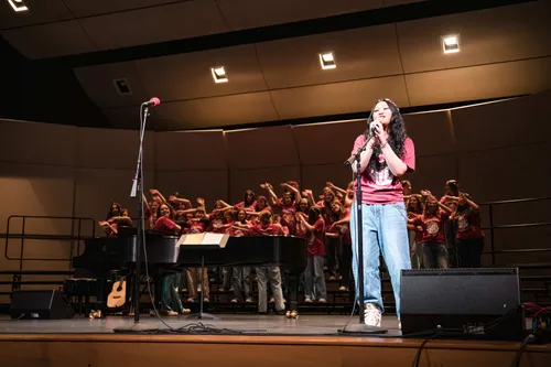 Soloist singing with the choir dancing behind
